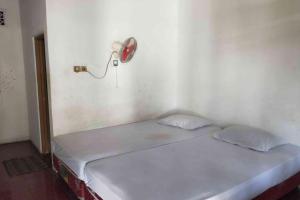 a bed in a room with a red fan at SPOT ON 93436 Penginapan Mekar Sari in Kuripan
