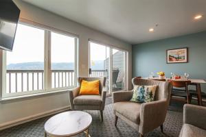 a living room with chairs and a table and windows at Sq Orca Oasis in Port Townsend