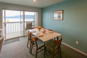 a dining room with a table with chairs and a balcony at Sq Orca Oasis in Port Townsend