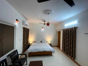 a bedroom with a bed and a chair at Poonam Palace near by Airport in Jodhpur