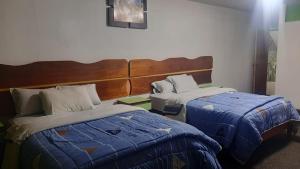 a hotel room with two beds and a headboard at Sierra Verde - Muy Céntrico Hs in Huancayo
