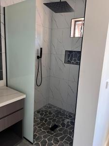 La salle de bains est pourvue d'une douche et de carrelage. dans l'établissement Mirah's Villa & Apartments, 
