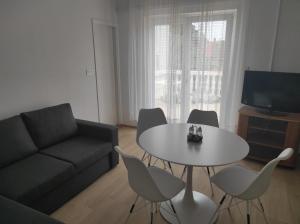 a living room with a couch and a table and chairs at Apartments Big - free parking in Vodice
