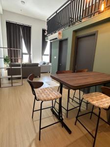 a living room with a wooden table and chairs at Iskandar Puteri Sunway Grid Residence Deluxe Loft by Ningle Loft in Kampong Pendas