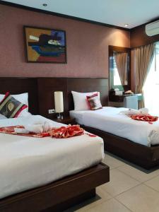 a hotel room with two beds and a mirror at LUCKY WAYS PATONG HOTEL in Patong Beach