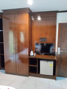 a kitchen with a tv and a counter with a refrigerator at LUCKY WAYS PATONG HOTEL in Patong Beach