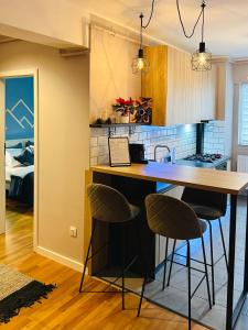 cocina con encimera y taburetes en una habitación en Blue Mountain Residence, en Brasov