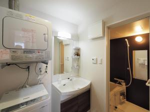 La petite salle de bains est pourvue d'un lavabo et d'un miroir. dans l'établissement Condominium L's INN, à Naha