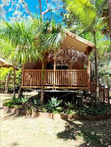 a resort cabin with a deck in the woods at Captain Cook Holiday Village 1770 in Seventeen Seventy