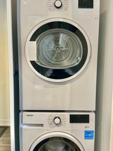 a washing machine and a dryer in a room at Cozy 2 Bedroom by Eaton Centre Mall in Toronto