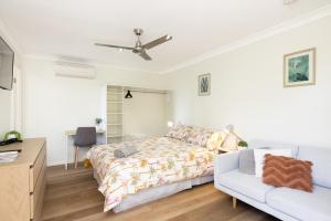 1 dormitorio con 1 cama y 1 sofá en Studio, Popcorn, Close to transport & Restaurants! en Brisbane