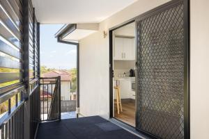 una puerta de cristal que da al balcón de una casa en Studio, Popcorn, Close to transport & Restaurants! en Brisbane