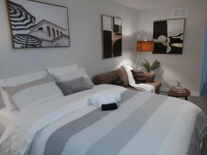 a bedroom with a large white bed and a couch at RB Homes in Ottawa
