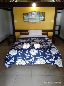 a bedroom with a bed with a blue and white comforter at Serenity Bungalows in Port Olry