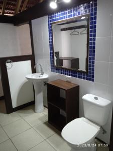 a bathroom with a toilet and a sink and a mirror at Serenity Bungalows in Port Olry