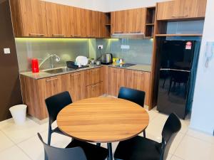 a kitchen with a wooden table and chairs at Hygge Living@Sunway Onsen in Tambun