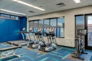 a gym with a row of tread machines in a room at 2br Skyline Apt With Panoramic Views Downtown in Des Moines