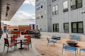 a patio with chairs and tables and a building at 2br Skyline Apt With Panoramic Views Downtown in Des Moines