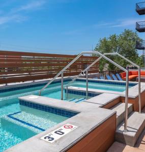 a large swimming pool with stairs in the water at 2br Skyline Apt With Panoramic Views Downtown in Des Moines