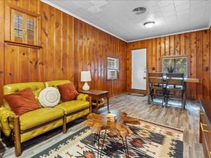 ein Wohnzimmer mit einem gelben Sofa und einem Klavier in der Unterkunft 1br Residence With Vast Backyard in Des Moines