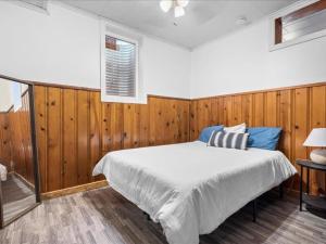 Schlafzimmer mit einem Bett mit Holzwänden und einem Fenster in der Unterkunft 1br Residence With Vast Backyard in Des Moines