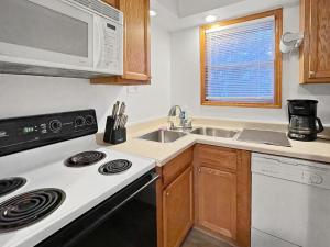 a kitchen with a stove and a sink and a microwave at 3bed Cozy House In Quiet Neighborhood in Des Moines