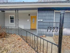 a house with a yellow door and a porch at 3bed Cozy House In Quiet Neighborhood in Des Moines