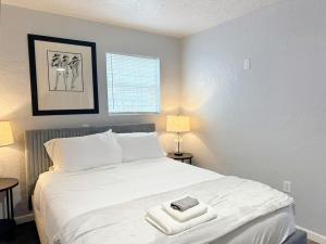 a bedroom with a white bed with two towels on it at Cozy 1 Bedroom W Rainshower I Mins To Downtown in Oklahoma City