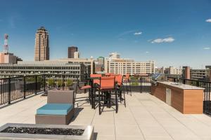 een balkon met tafels en stoelen op een skyline van de stad bij 2 Br Downtown Apartment With Gym & Hot Tub in Des Moines