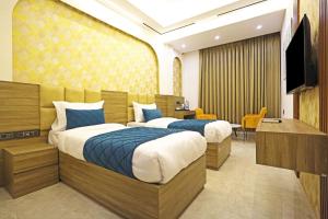 The Armani Hotel At Delhi Airport في نيودلهي: غرفة فندقية بسريرين وتلفزيون بشاشة مسطحة