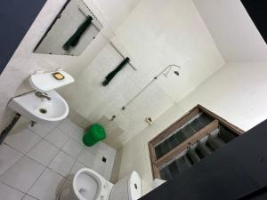 La salle de bains est pourvue de toilettes et d'un lavabo. dans l'établissement HOTEL 229 42, à Cotonou