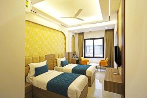 The Armani Hotel At Delhi Airport في نيودلهي: غرفه فندقيه سريرين وتلفزيون