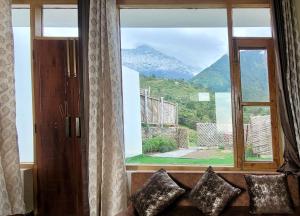 una finestra con vista sulle montagne di Salig Hotel a Dharamshala