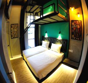 ein Schlafzimmer mit einem Bett in einem Zimmer mit grünen Wänden in der Unterkunft OYO 90899 Tube Hotel Melaka in Kelebang Besar