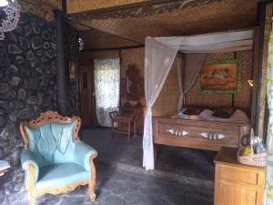 a bedroom with a bed and a chair at Yoschi's Hotel Bromo in Ngadisari