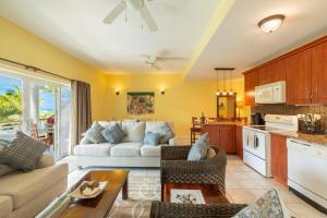 a living room with a couch and a kitchen at The Island Cottage-Oceanview-Steps to Grace Bay in Providenciales