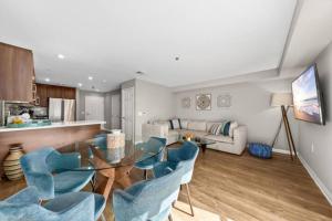 a living room with a glass table and blue chairs at Exquisite Ocean View 2-Story Haven Top floor in Los Angeles