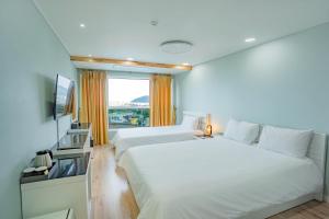 Postel nebo postele na pokoji v ubytování Hotel Sweet Castle Jeju Hamdeok