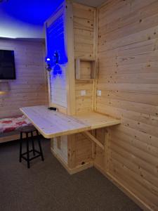 uma sauna com uma mesa e um banco num quarto em Magnoliowy Zakątek em Idzików