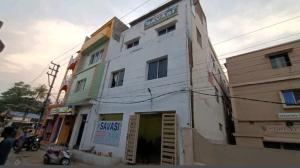 um edifício branco ao lado de uma rua em Goroomgo Savashi Puri em Puri
