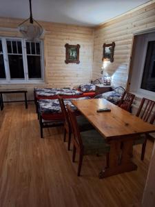 a living room with a wooden table and chairs at Magnoliowy Zakątek in Idzików