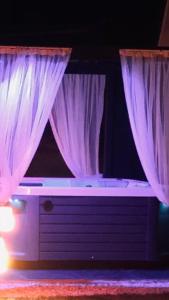 a stage with purple curtains and a bed with avisor at Happy House Bungalov Three-Room SPA JAKUZİ Lake view in Sapanca B2 in Sapanca