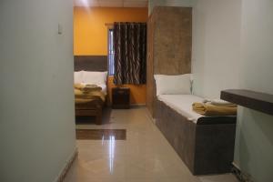 a small room with two beds and a window at Hotel Sikara, Kumbakonam in Kumbakonam