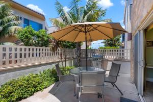 een tafel en stoelen met een parasol op een patio bij Bay View Beach House - Your Coastal Retreat in San Diego