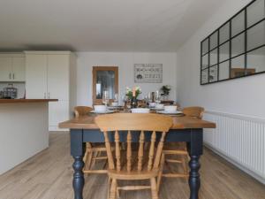 a kitchen and dining room with a table and chairs at The Hideaway Beach House in New Romney