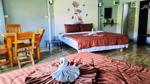 a hotel room with two beds with swans on them at Cashewnut Tree Resort in Ko Lanta