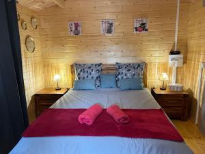 una camera da letto con un letto e due pantofole rosa sopra di Les Chalets de Marie & Steph 2 - Vue mer, Jacuzzi SPA privatif Sans vis à vis a Saint-Denis