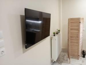 a television hanging on a wall next to a refrigerator at Nikou Nikolaou Apartment in Serres