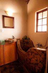 a bathroom with a sink and a wooden tub at Bushvilla's Silonque in Phalaborwa