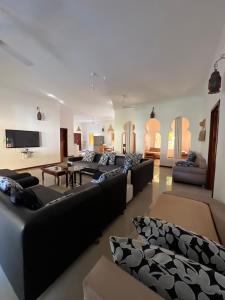 a large living room with couches and a flat screen tv at UKAYA VILLA in Paje